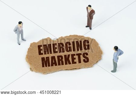 Economy And Business Concept. On A White Background, Figures Of Businessmen And Torn Cardboard With 