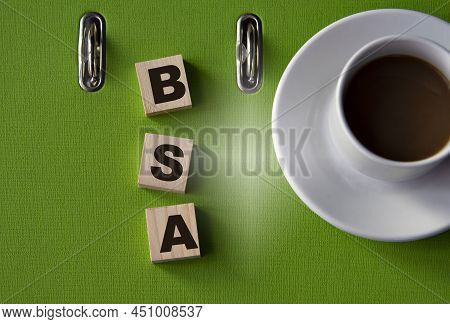 Bsa - Acronym On Wooden Cubes Against The Background Of A Green Folder And A Cup Of Coffee. Business