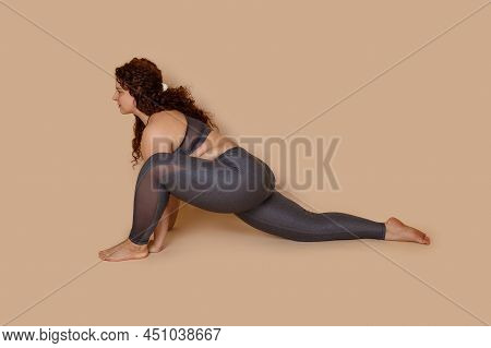 Goal Oriented Obese Overweight Woman Doing Sports Stretch, Sitting Half Splits. Spine And Muscles. B