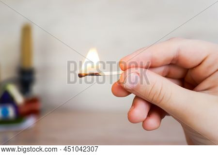 The Child Holds A Lit Match And It Burns With A Flame