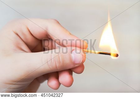The Child Holds A Lit Match And It Burns With A Flame