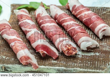 Minced Meat Wrapped In Bacon On Cast Iron Plate. Chevapchichi Or Kofta Kebab. Raw Sausages Of Ground