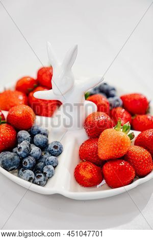 Strawberries And Blueberries In A White Compartmental Dish With Rabbit.