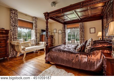Furnished Bedroom Within Former Victorian Rectory With Ornate Carved Four Poster Bed And Matching Pe