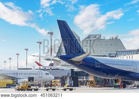 Aircraft In Pre-flight Maintenance And Their Tails At The Airport Next To The Passenger Terminal