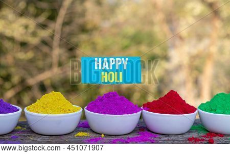 Happy Holi Wish With Organic Holi Festival Powder Colors Or Gulal In White Bowl On Wooden Background