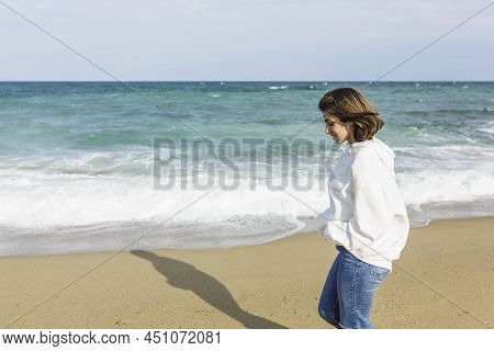 Young Relaxed Woman Enjoying And Walking Alone On The Beach - Copy Space On The Left Side