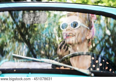Beautiful Stylish Woman In Vintage Bright Dotted Clothes, Sitting In Mint Old Car. Fashion Pin-up Gi
