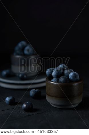 Fresh Blueberries In A Gray Ceramic Bowl On Black Concrete And Black Background.