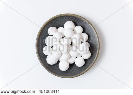 White Sugar Balls In A Gray Ceramic Plate On A White Background. Close Up Top View.