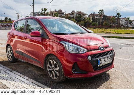 Side, Turkey - February 28 2022: Red  Hyundai I10  Is Parking  On The Street On A  Summer Day Agains