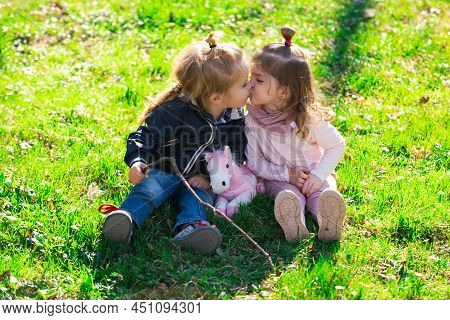 Cute Love. Little Girl Kissing Little Boy Outdoors In Park. Lifestyle Portrait Baby Child In Happine