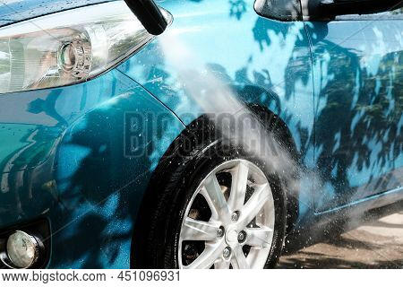 Car Wash At Home Alone. Car Wash High Pressure Close-up. A Man Washes A Green Car.