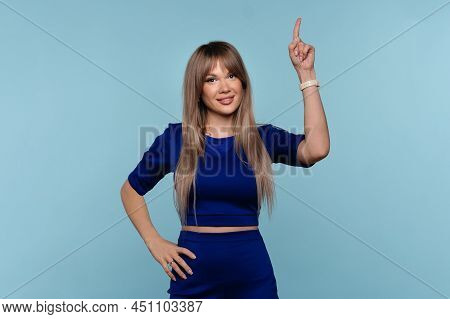 Nice Blonde Woman Wear Blue Suit Point Up Forefinger. Pretty Girl Showing Promo, Pointing Index Fing