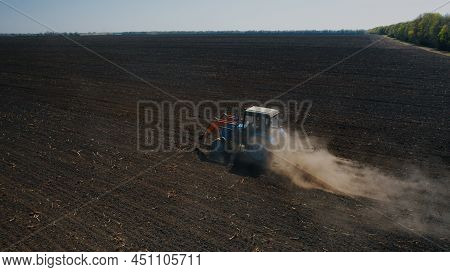 Farming: A Farmer On A Tractor Works The Field Before Sowing