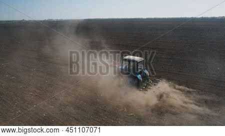 Farming: A Farmer On A Tractor Works The Field Before Sowing