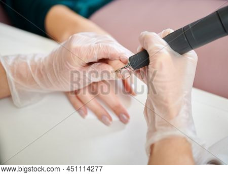 Manicurist Using Cuticle Remover Device While Doing Hardware Manicure In Beauty Salon. Close Up Of F
