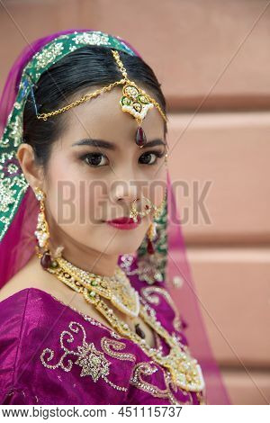 Portrait Asian Woman In A Margenta Indian Tradition Sari, She Is Looking At A Camera Next To The An 