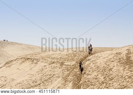 Pilat, France - February 22, 2022: Family Of Tourists, Parents With Children, Climbing The Pilat Dun