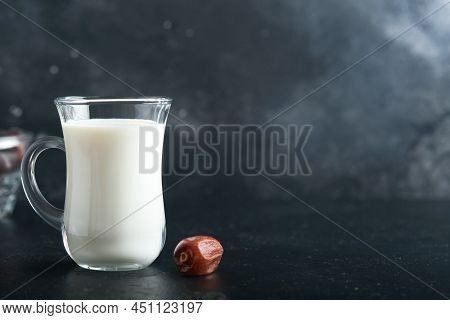 Ramadan Kareem Food And Drinks. Plate Of Dates, Glass Of Milk And Date Palm Branch On Black Backgrou