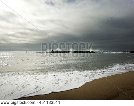 Giant Waves Breaking On The Breakwater And The Lighthouse On Aguda Beach, Miramar, Arcozelos Town