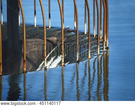 Closeup Shows Lake Water Pouring Over Spillway On Lake Claiborne In Louisiana.  Metal Bars Prevent D