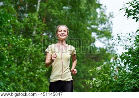 Running Woman Atletic Spotsman Trains In The Summer Park. Outdoor Fitness Portrait After Rain