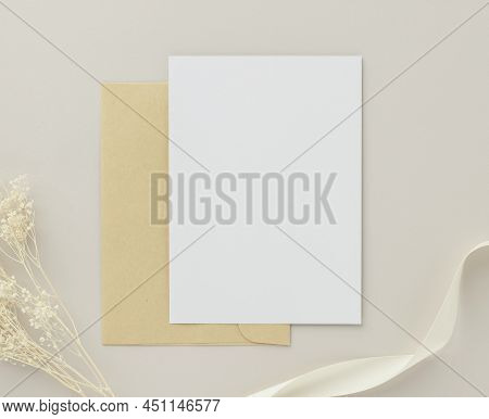 Blank Greeting Card Invitation Mockup 5x7 On Brown Envelope With Dried Flowers On Beige Background, 