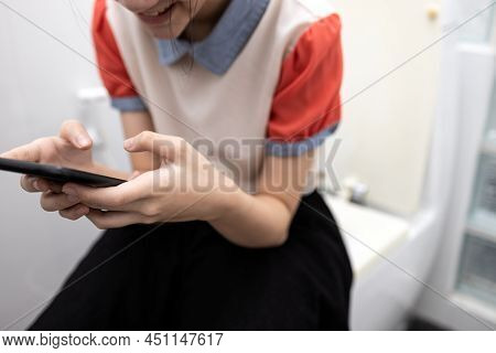 Asian Student Using Mobile Phone Playing Games,social Network Or Chat With Friends,sending Messages,