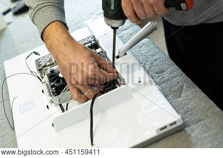 Minsk, Belarus - Dec 15, 2021: Photo Of Hands Assembles A Computer Monitor System Block On An Convey