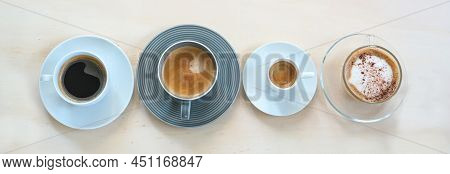 Four Cups With Various Coffee, Espresso, Cappuccino, Lungo, Black And With Crema On A Light Wooden T