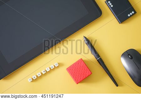 Stylus And Graphics Tablet For Drawing On Yellow Background, Next To An External Ssd, Computer Mouse