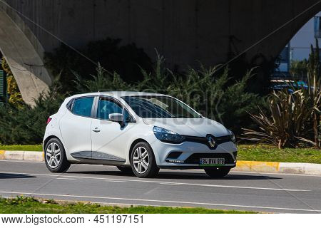 Antalya; Turkey - March 04 2022:  White Renault Clio   Is Driving Fast On The Street On A Warm Summe