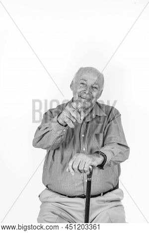 Happy Elderly Man Sitting In Front Of A White Background Giving Handsign