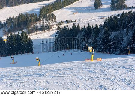 Skiers Go Down The Slope At Slotwiny Arena Ski Station On A Sunny Day, Krynica Zdroj, Poland