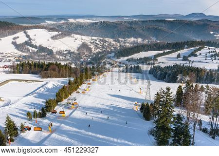 Skiers Go Down The Slope At Slotwiny Arena Ski Station On A Sunny Day, Krynica Zdroj, Poland