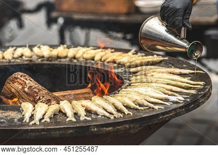 Preparing Traditional Tasty European Smelt Fried Fish Being Cooked On An Open Fire In A Regional Str