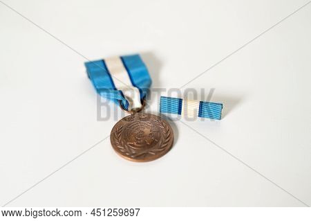 Shallow Focus Shot Of The Front Of A United Nations Peacekeeper's Medal And Service Ribbon On A Whit