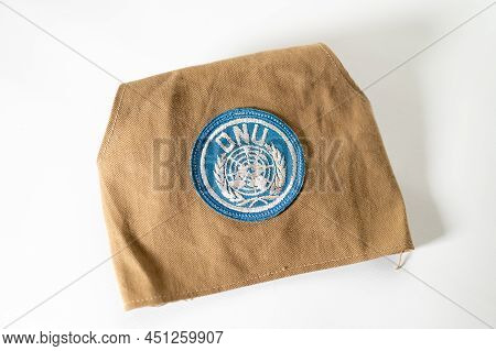 Overhead Shot Of United Nations Peacekeeper's Armband With Sewn On Un Badge On A White Background