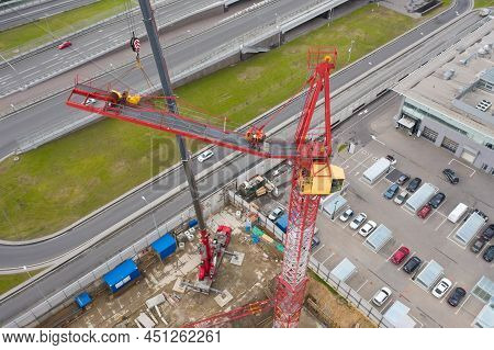 Installing The Jib Of A Construction Crane Using Another Crane On The Truck, The Work Of The Builder