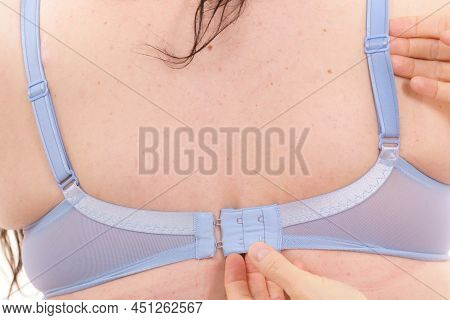 The Importance Of Wearing Proper Fitting Bras. Bra Fitter Helping Plus Size Chubby Woman Find Perfec