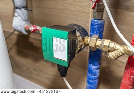 Circulation Pump For Hot Water In A Modern Gas Boiler Room Lined With Ceramic Tiles.