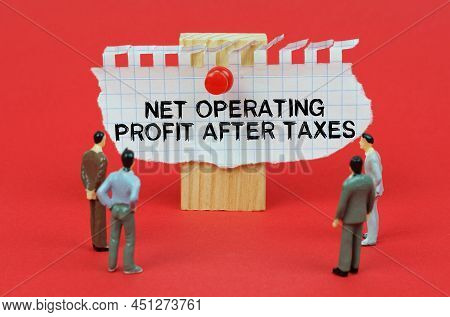 Business Concept. On A Red Background Are Miniature Figures Of People Looking At An Ad With The Insc