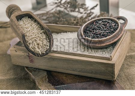Various Types Of Rice : Brown Rice, Jasmine Rice And Riceberry On Old Wooden Background. Organic Raw