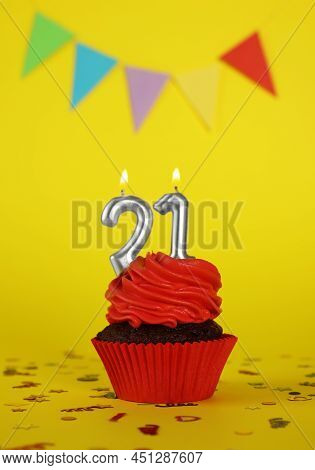 Delicious Cupcake With Number Shaped Candles On Yellow Background. Coming Of Age Party - 21th Birthd