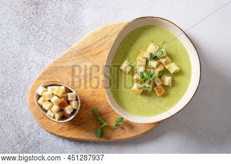 Fresh Broccoli Soup With Croutons And Micro Green In A Bowl On A Gray Background. Spring Vegan Recip
