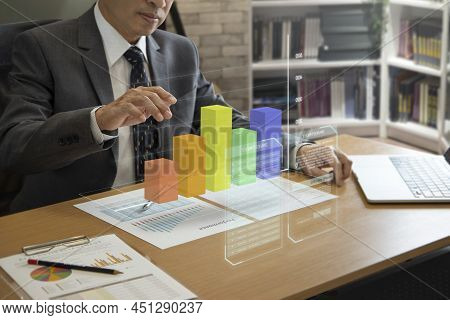 Asian Businessman Interacting With Augmented Reality Three-dimensional Bar Graph While Analyzing A R