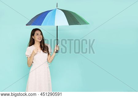 Young Asian Woman Holding Umbella Standing Isolated On Green Background