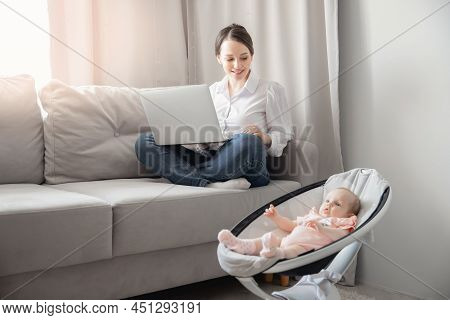 Closeup Baby In Automatic Carrycot, Businesswoman Working At Home Office Using Laptop Computer With 