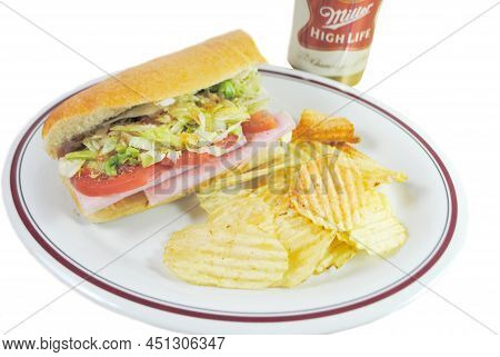 A Sub Sandwich With Potato Chips Served As A Cold Lunch With A Can Of Miller Highlife Beer In The Ba